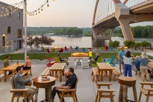 People enjoying the patio at a hotel restaurant overlooking the Mississippi River